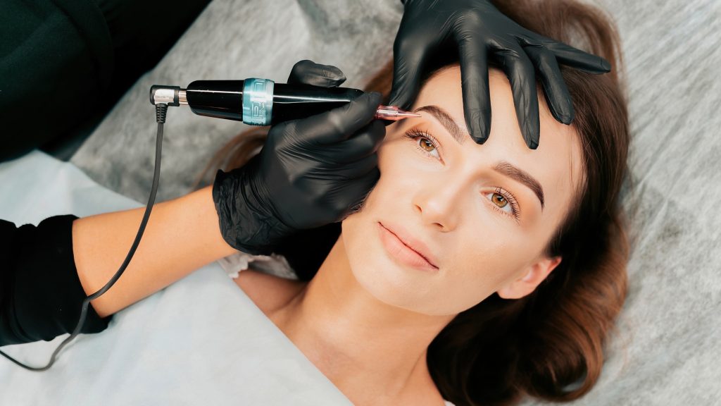 Make-up master performs the procedure of permanent eyebrow makeup